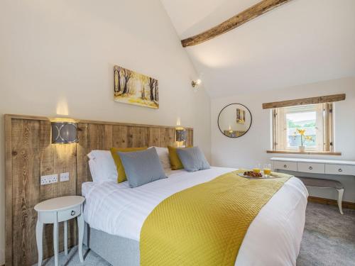 a bedroom with a large bed with a yellow blanket at Riverside Dairy in Bamford