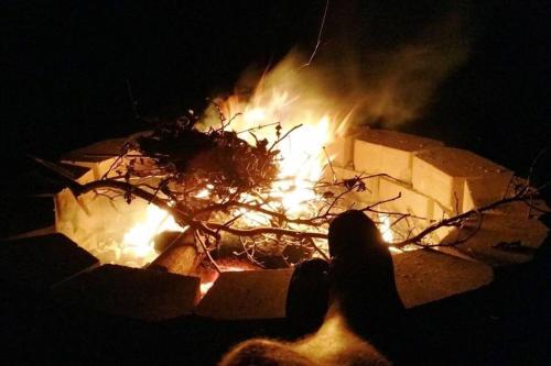 a person sitting in front of a fire at night at Lakefront: Dock, Hot Tub, Fire Pit & Home Theater in Winchester