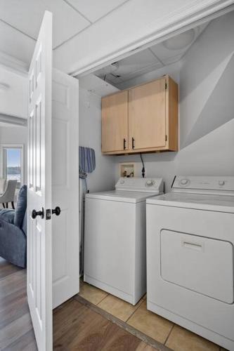a white laundry room with a washer and dryer at Lakefront: Dock, Hot Tub, Fire Pit & Home Theater in Winchester