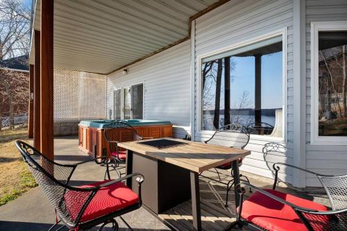 patio con sedie e tavolo sul portico di Lakefront: Dock, Hot Tub, Fire Pit & Home Theater a Winchester