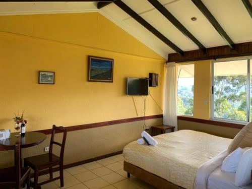 - une chambre avec un lit, une table et une fenêtre dans l'établissement Hotel Colinas Altavista, à Tarbaca