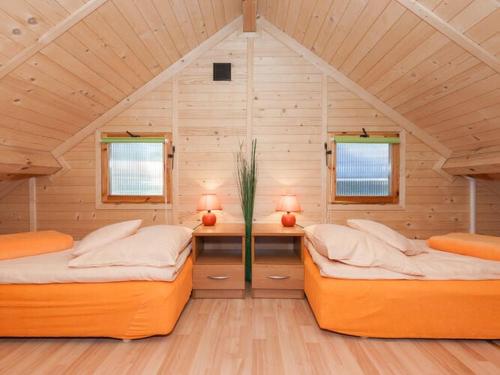 an attic room with two beds and two windows at Holiday houses near the seaside beach, Pobierowo in Pobierowo