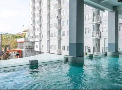 una piscina frente a un gran edificio en Easton Park Residence Jatinangor - GIANDARA, en Sayang