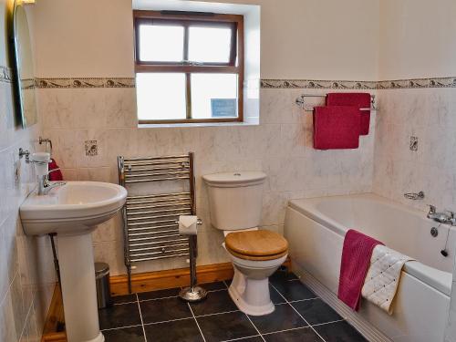 y baño con lavabo, aseo y bañera. en Elidir Cottage, en Llanwnda