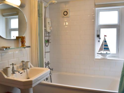 a bathroom with a sink and a bath tub at Mouse House in Hastings