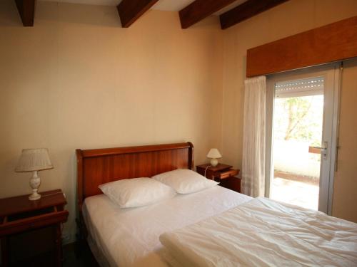 une chambre avec un lit avec des draps blancs et une fenêtre dans l'établissement Villa avec jardin boisé, proche plage et commerces, La Tranche-sur-Mer - FR-1-22-307, à La Tranche-sur-Mer