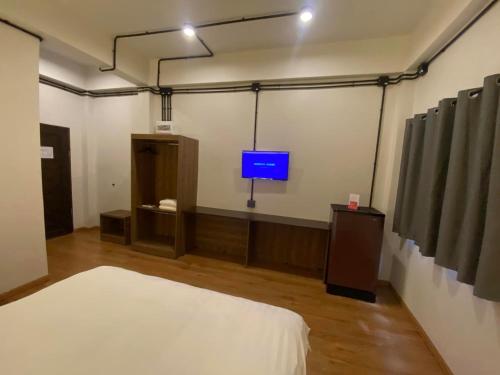 Habitación con cama y TV en la pared. en Red Heritage Hotel, en Ban Mon