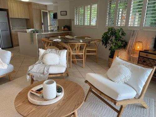 a kitchen and living room with a table and chairs at Ocean view apartment! 300m to beach. Pet friendly. in Alexandra Headland