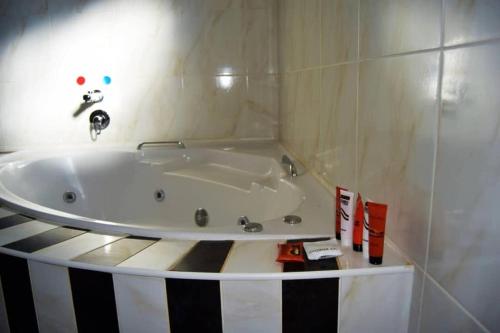 a bathroom with a bath tub in a room at Homey Guesthouse in Gaborone
