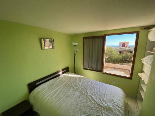 une chambre verte avec un lit et une fenêtre dans l'établissement Villa T2+Mezzanine, 6 pers, plage, parking, Port Leucate - FR-1-81-582, à Port-Leucate