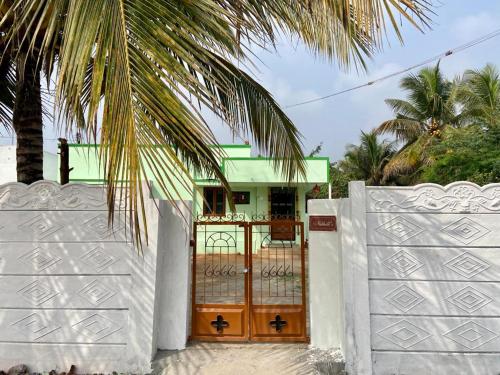 une porte en face d'une maison avec un palmier dans l'établissement Castle50 - Green Villa homestay, à Coimbatore