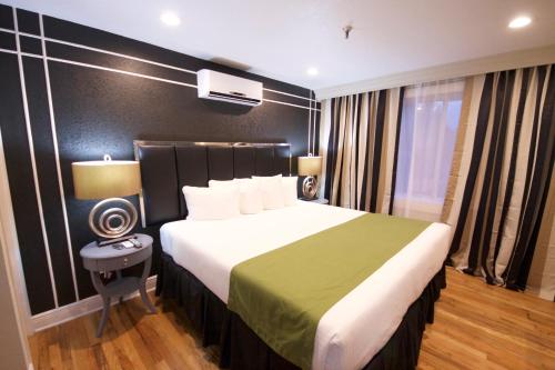 a hotel room with a large bed with a green blanket at Hyde Park Hotel in Tampa