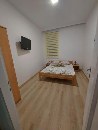 a room with a bed and a television in it at Platan 2 in Bela Crkva