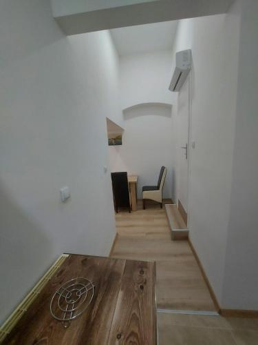 - un salon avec une table et un mur blanc dans l'établissement Platan 2, à Bela Crkva
