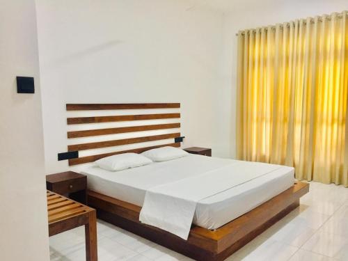 a bedroom with a large bed and a window at Swan Lake Habarana in Habarana