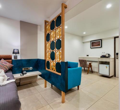 un soggiorno con divano blu e tavolo di Hotel Landmark By Pai a Belgaum