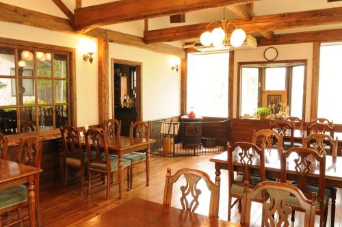 a dining room with wooden tables and chairs at Pension Syo in Hakuba