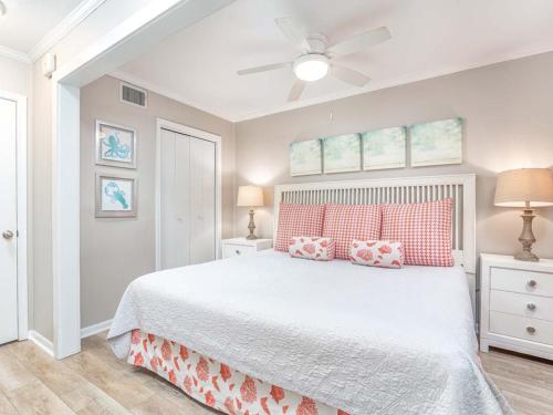 um quarto com uma cama branca e uma ventoinha de tecto em Beach Racquet A126 em Tybee Island