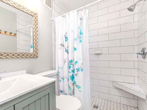 biała łazienka z zasłoną prysznicową i toaletą w obiekcie Beach Racquet A126 w mieście Tybee Island