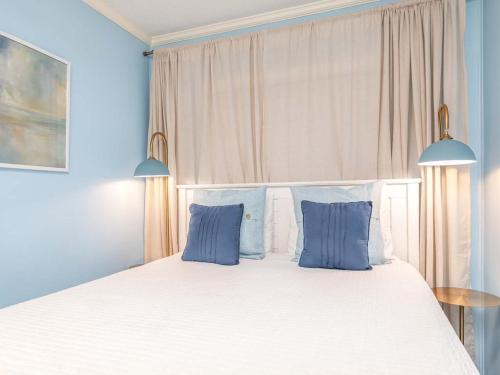 a bedroom with a large white bed with blue pillows at Beach Racquet A315 in Tybee Island