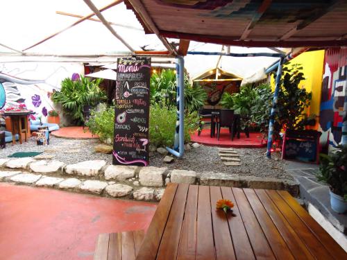 an outdoor patio with a wooden table and a sign at Casona Don Juan Hostel in San Gil