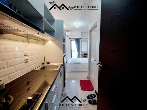 White Studio Group Surabaya - WS 821 at Amega Crown Residence في Tambakoso: مطبخ صغير مع حوض و كونتر توب