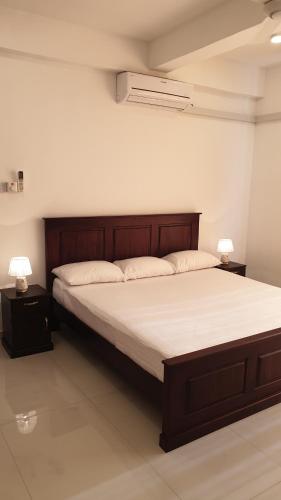 1 cama en una habitación con 2 lámparas en las mesas en Rodrigo Apartments, en Boralesgamuwa