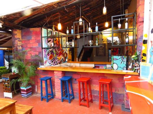 a bar with red and blue stools in a restaurant at Casona Don Juan Hostel in San Gil