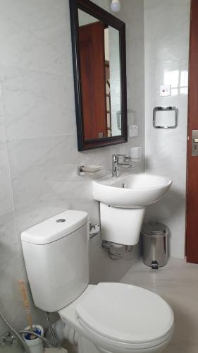 Baño blanco con aseo y lavamanos en Rodrigo Apartments, en Boralesgamuwa