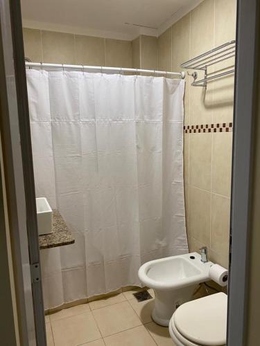 łazienka z toaletą i białą zasłoną prysznicową w obiekcie Edificio Giu 1 w mieście San Salvador de Jujuy
