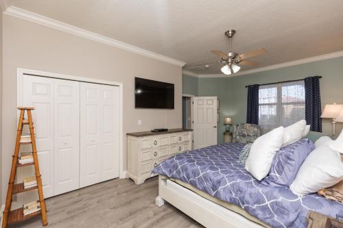 a bedroom with a bed and a flat screen tv at SouthernVilla Ticket to Paradise in Palm Coast