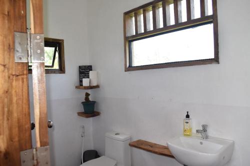 uma casa de banho com um WC, um lavatório e uma janela em Pacifico Surf Bayay 