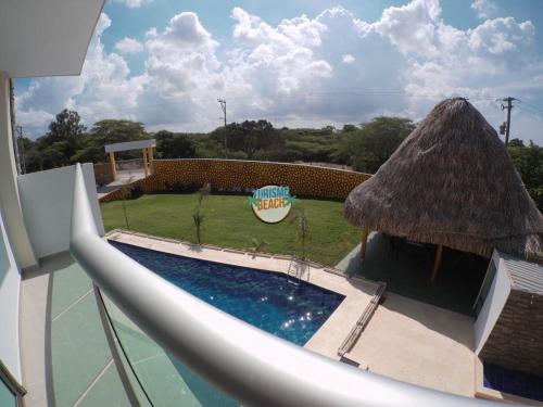 a pool with a slide and a grass roof at Special Life Beach in Tubará