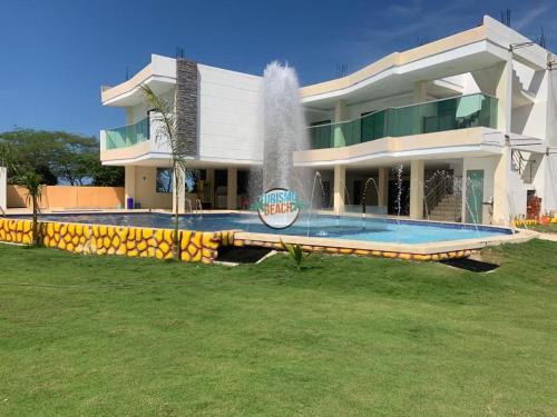 a large house with a fountain in front of it at Special Life Beach in Tubará