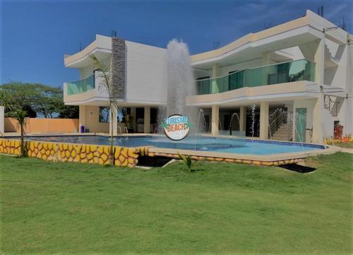 a large house with a fountain in front of it at Special Life Beach in Tubará