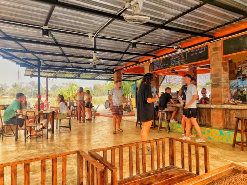 a group of people standing around in a restaurant at Cody Backpackers in Pai