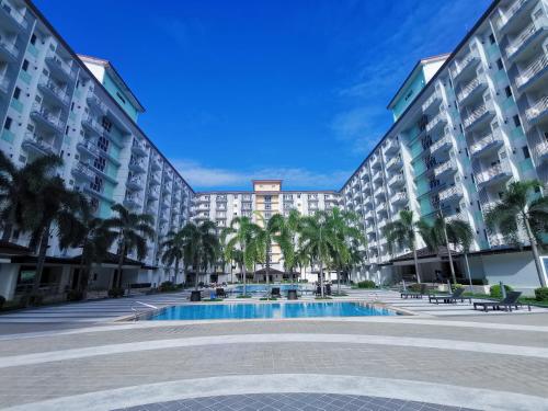 a resort with a swimming pool and palm trees at Field Residences Bldg5 in Manila
