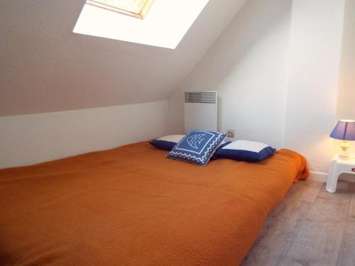 - une chambre avec un lit et une couverture orange dans l'établissement Duplex refait à neuf à Carnac - 3 chambres, balcon sud, parking, 300m de la plage - FR-1-477-145, à Carnac