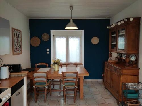 Il comprend une cuisine avec une table et des chaises en bois. dans l'établissement Maison bord de mer avec jardin et parking privé - FR-1-542-41, à Pleumeur-Bodou