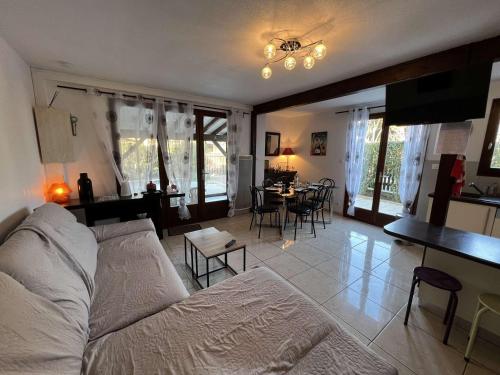 un salon avec un canapé, une table et des chaises dans l'établissement Maison 5 pièces avec piscine, près de la plage, idéal pour familles, à Vendres - FR-1-701-15, à Vendres