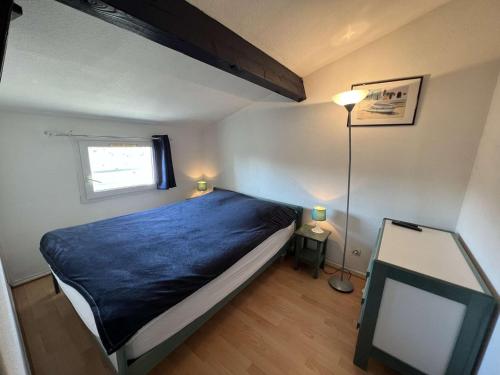 um quarto com uma cama com um cobertor azul em Maison Vendres, 2 pièces, 4 personnes - FR-1-701-41 em Vendres