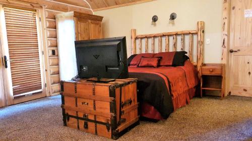 a bedroom with a bed and a tv on a chest at Teton Hostel HideAway in Driggs