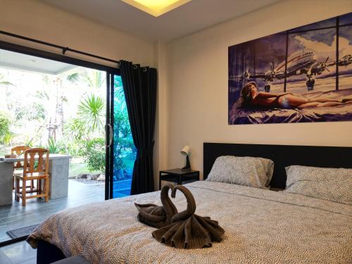 a bedroom with a bed with a large painting on the wall at Sunset resorts and bar in Ban Nong Chaeng