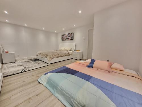 um quarto branco com uma cama e um quarto com uma cama quadrada em 4 Bedrooms Beautiful Townhouse em Montreal