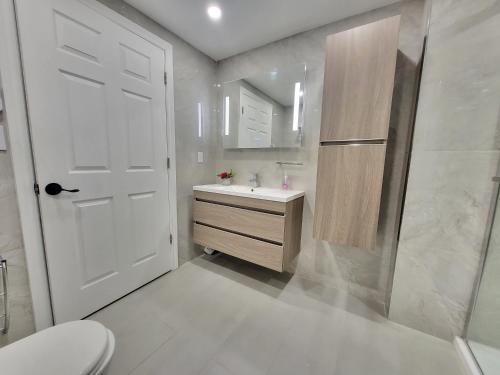 a bathroom with a toilet and a sink and a door at 4 Bedrooms Beautiful Townhouse in Montréal