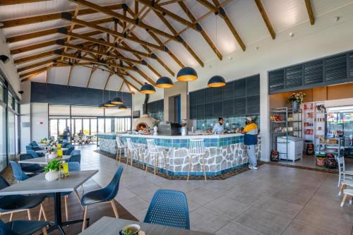 a restaurant with a bar with blue chairs and people standing at a counter at BALLITO HILLS, 1 bedroom apartment in Ballito