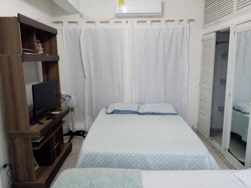 een kleine slaapkamer met 2 bedden en een televisie bij Alojamiento Arte y Salud in Cartagena