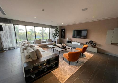 uma grande sala de estar com um grande sofá e cadeiras laranja em 5350 Park inn Suite em Miami
