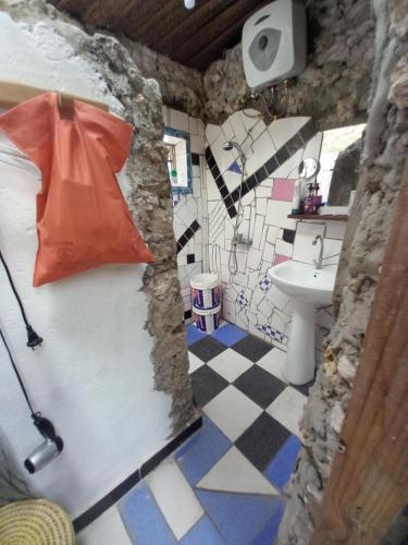 a bathroom with a sink and an umbrella on the door at Bibi Mrembo Guesthouse in Pingwe