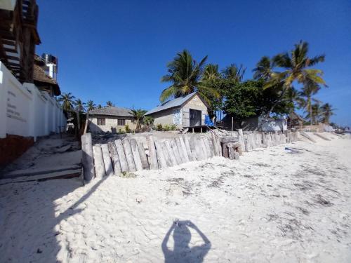 a shadow of a person walking on the beach at Bibi Mrembo Guesthouse in Pingwe